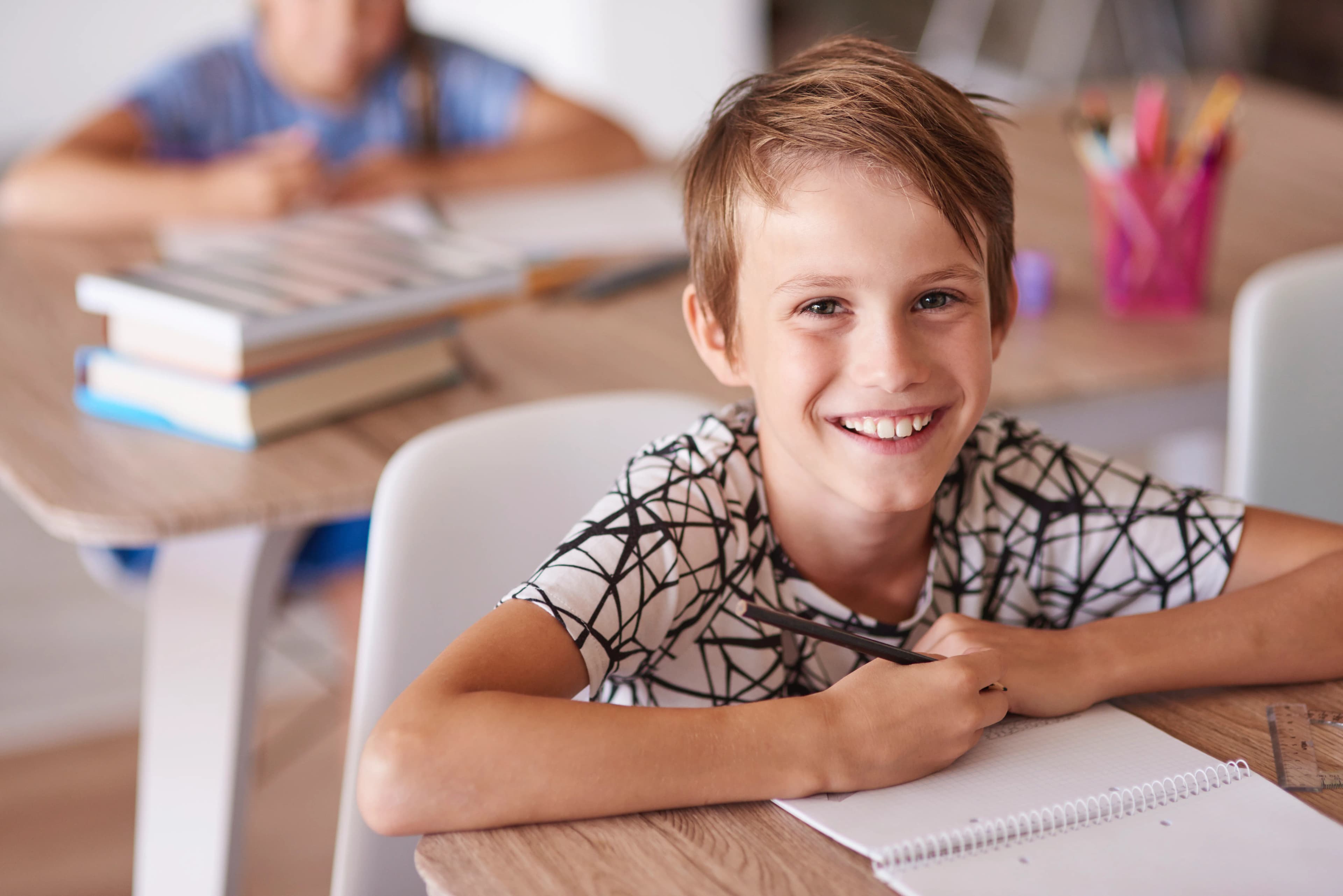 Studente sorridente alla scrivania a scuola