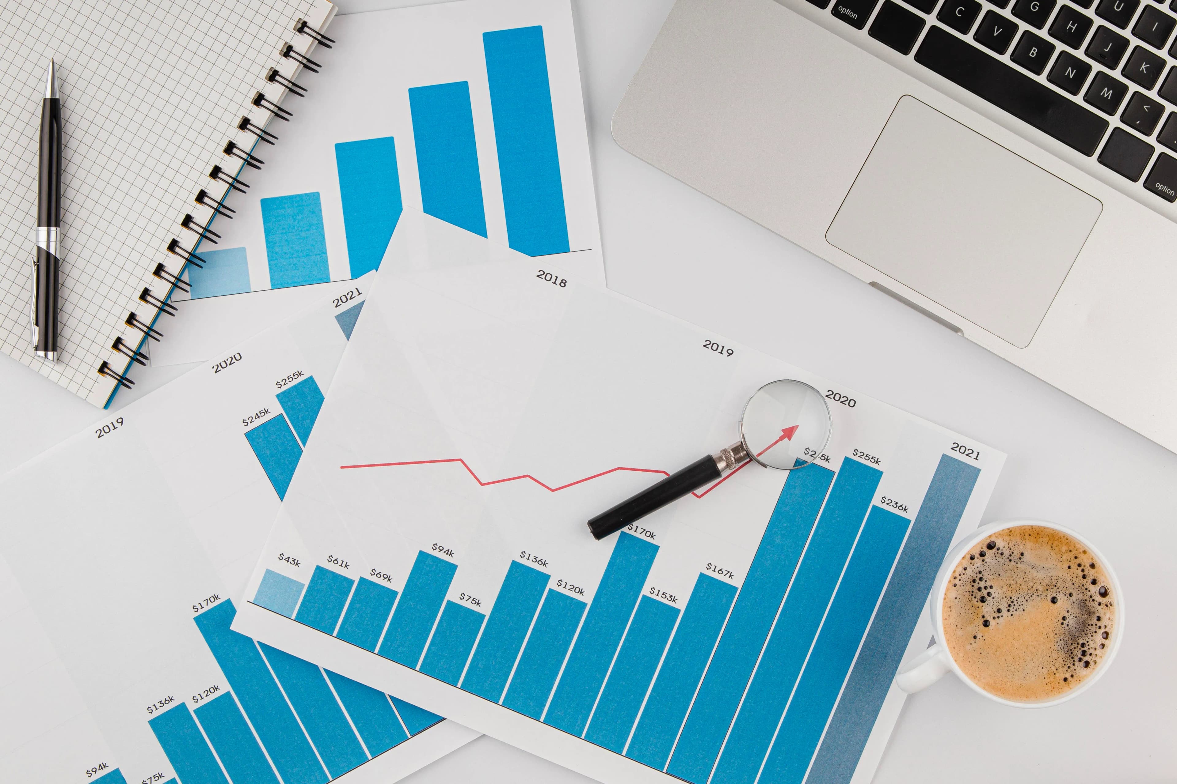 Scrivania con laptop, grafico di crescita e materiale di studio — economia e statistica